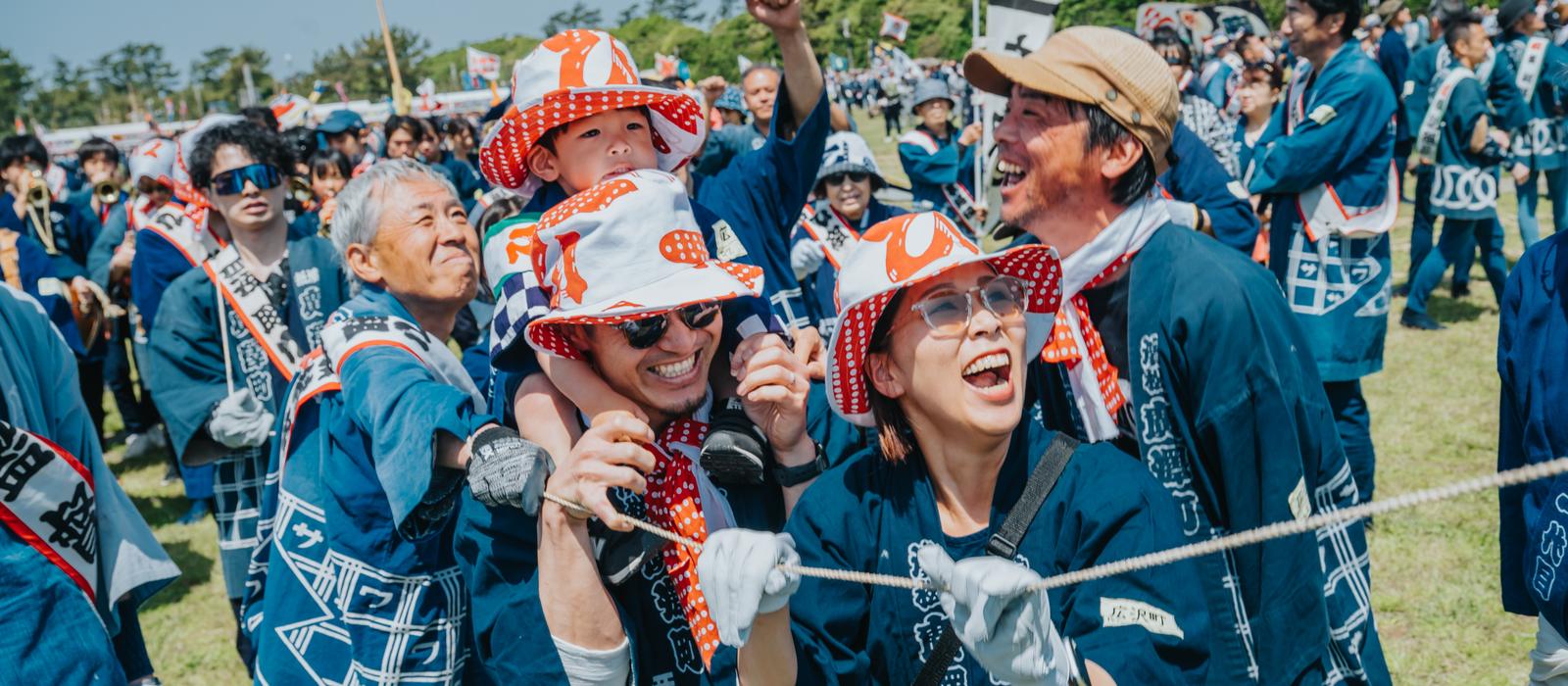 祭りで肩車をして歓声をあげる家族