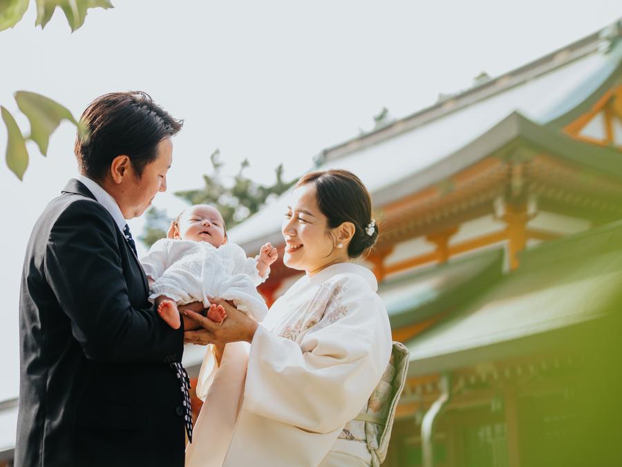 神社でのお宮参り、赤ちゃんを抱くご両親